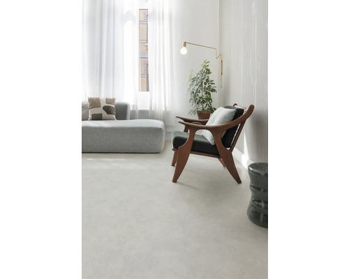 Světlý obývací pokoj s pohovkou, křeslem, stojací lampou a pokojovou rostlinou