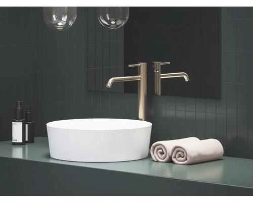 Moderní koupelna s umyvadlem na desku, vodovodní baterií a ručníky