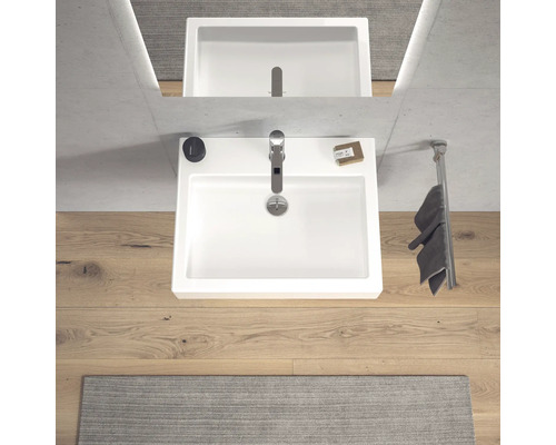 Pohled shora na umyvadlo s baterií, mýdlem a držákem na ručníky v koupelně