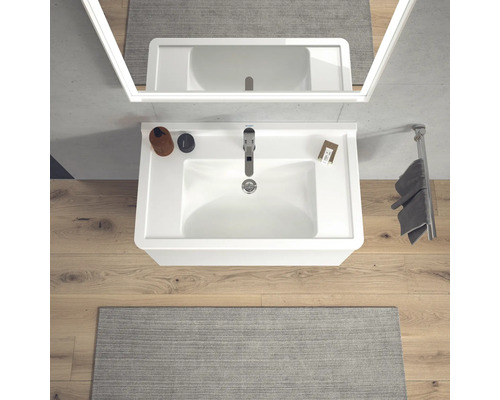 Koupelnové umyvadlo s baterií, zrcadlem a držákem na ručníky ve světlé koupelně