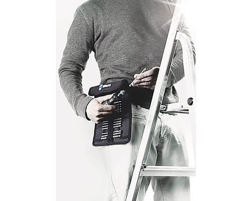 Muž se sadou nářadí Wera na opasku a žebříkem v pozadí.