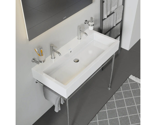 Bílé umyvadlo s chromovaným rámem a armaturami v koupelně