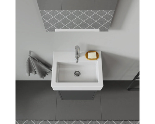 Pohled shora na koupelnu s umyvadlem, baterií, miskou na mýdlo a držákem na ručníky