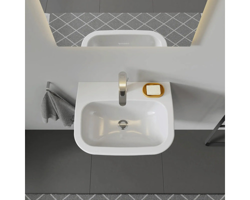 Pohled shora na umyvadlo s vodovodní baterií a mýdlem v koupelně