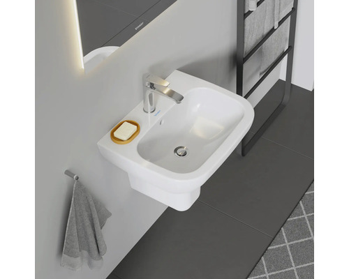 Fotografie koupelny s bílým umyvadlem, mýdlenkou a vodovodní baterií.