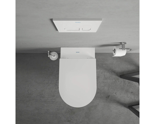 Pohled shora na toaletu se splachovací nádrží, držákem toaletního papíru a rohovým ventilem v koupelně