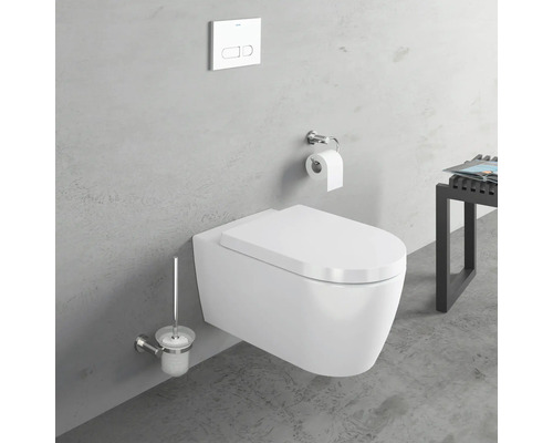 Závěsné WC s toaletní štětkou a splachovací nádržkou před šedou stěnou