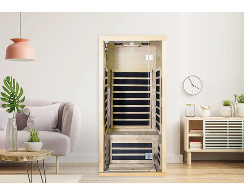 Interiérový pohled na dřevěnou infračervenou saunu se skleněnými prvky ve světlé místnosti