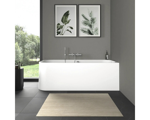 Moderní koupelna s volně stojící vanou, baterií a obrázky rostlin.