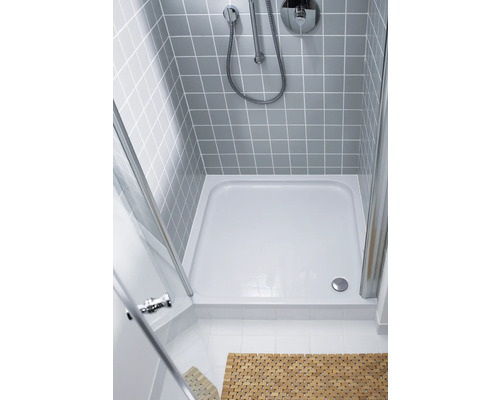 Sprchový kout se sprchovou vaničkou, baterií a sprchovou hlavicí na obložené stěně