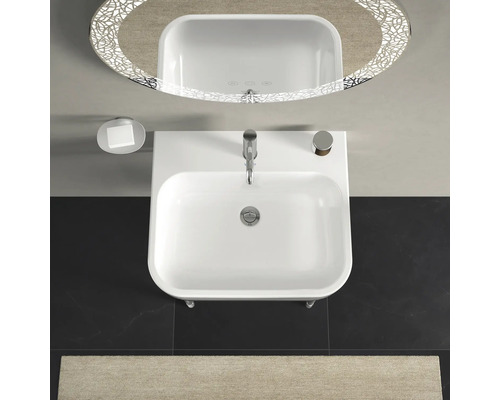 Pohled shora na umyvadlo s baterií, mýdlenkou a osvětleným zrcadlem v koupelně.