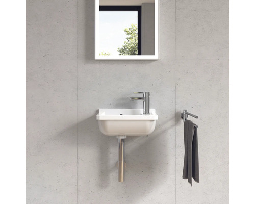 Kompaktní umyvadlo s baterií, zrcadlem a držákem na ručníky namontované na stěně.