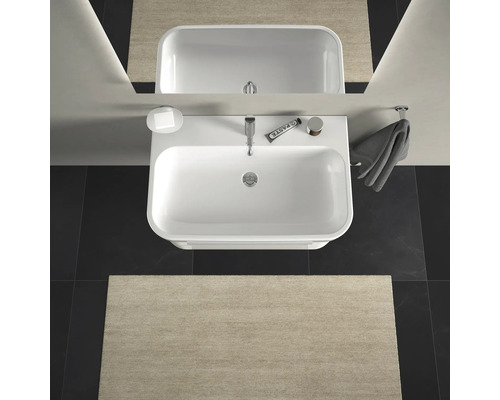 Pohled shora na koupelnu s umyvadlem, zrcadlem, ručníkem a koupelnovou předložkou