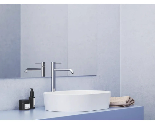 Moderní koupelna s umyvadlem na desku, baterií a kosmetikou