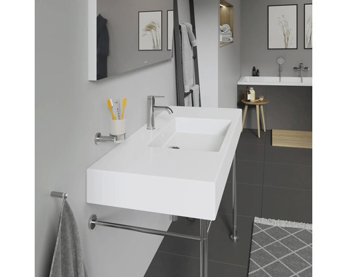 Moderní koupelna s bílým umyvadlem, držákem na ručníky a zrcadlem