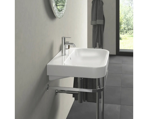 Umyvadlo s držákem na ručníky a vodovodní baterií v koupelně.