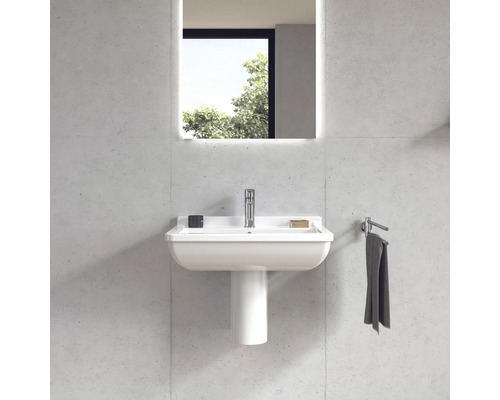 Koupelna s umyvadlem, umyvadlovým sloupem, baterií, ručníkem a osvětleným zrcadlem