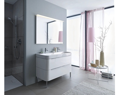 Moderní koupelna s umyvadlovou skříňkou, zrcadlem a sprchou.