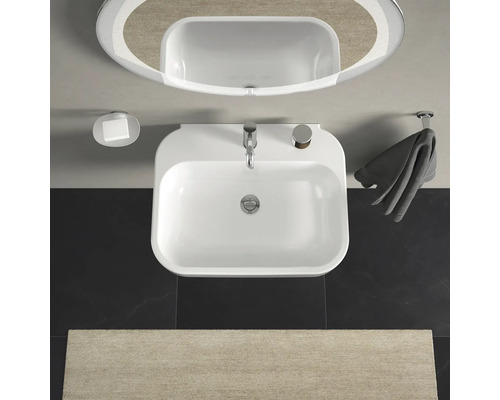 Pohled shora na koupelnu s umyvadlem, zrcadlem, mýdlenkou a držákem na ručníky