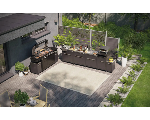 Pohled shora na venkovní kuchyni s grilem, dřezem, pecí na pizzu a pracovními plochami na dřevěné terase