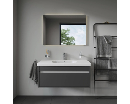 Moderní koupelna s umyvadlem, osvětleným zrcadlem a držákem na ručníky