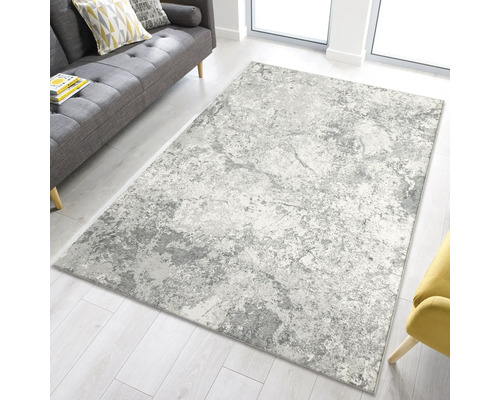 Šedo-bílý koberec v obývacím pokoji na světlé dřevěné podlaze