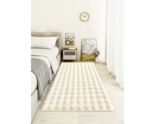 Ložnice s postelí, nočním stolkem a obdélníkovým kobercem