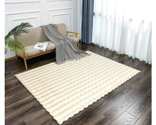 Obývací pokoj s pohovkou a vzorovaným obdélníkovým kobercem.