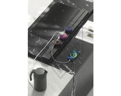 Kuchyňská scéna s indukční varnou deskou, napájecí lištou, varnou konvicí a smartphonem na kuchyňské lince