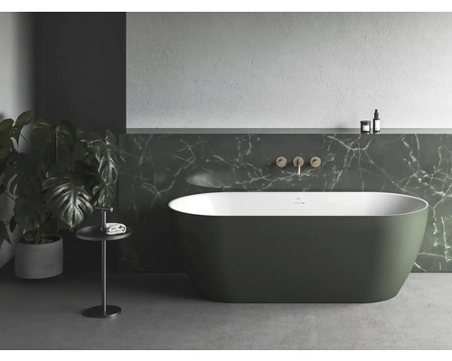 Volně stojící vana v koupelně s mramorovou stěnou a pokojovou rostlinou