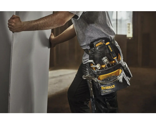 Řemeslník s brašnou na nářadí a sádrokartonovou deskou