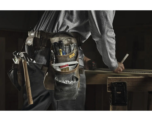 Řemeslník s nářadím a opaskem na nářadí při práci