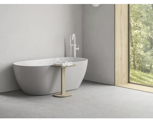 Volně stojící vana s armaturou a odkládacím stolkem v koupelně.