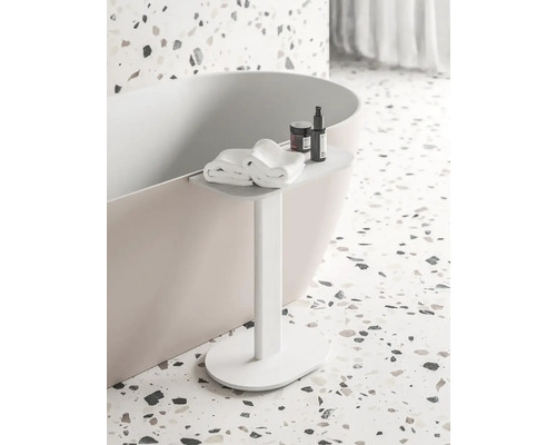 Koupelnová scéna s vanou, ručníky a koupelnovými doplňky na odkládacím stolku