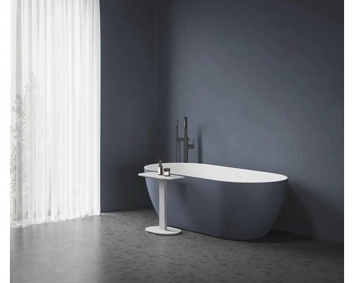 Volně stojící vana s baterií a odkládacím stolkem v koupelně.