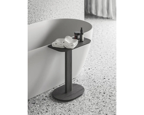 Koupelnová scéna s vanou, ručníky, kosmetickými produkty a odkládacím stolkem