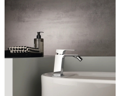 Bidetová armatura na umyvadle s ručníky a mýdlem v koupelně