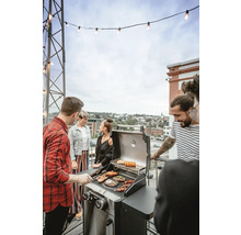 Skupina lidí griluje venku na plynovém grilu