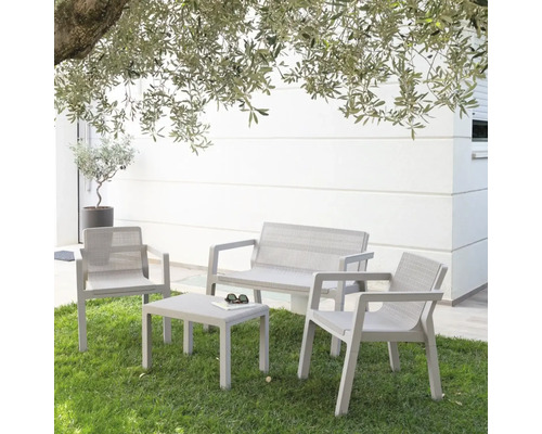 Zahradní sedací souprava s lavicí, židlemi a stolem na trávníku