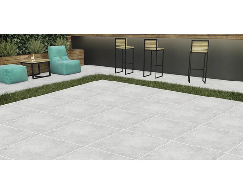 Terasa se světlou kamennou dlažbou, doplněná o lounge nábytek a barové stoličky