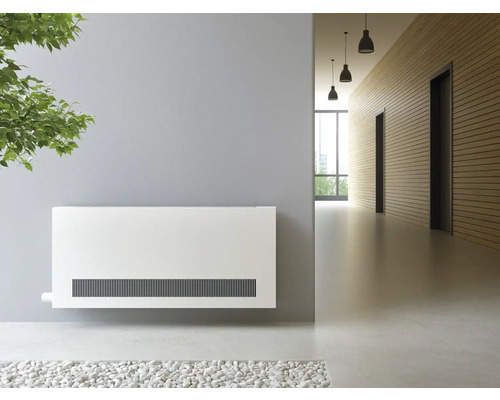 Scéna s bílým nástěnným konvektorem na chodbě.