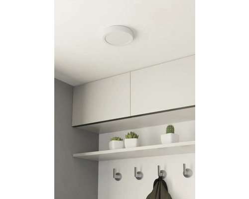 Pokoj se stropním svítidlem, skříněmi, policí a věšákem