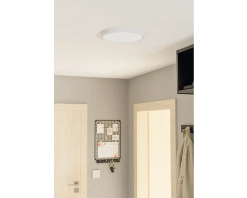 Stropní svítidlo v místnosti s dveřmi, nástěnkou na poznámky a věšákem na kabáty