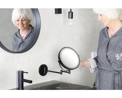 Koupelna s kulatým zrcadlem, umyvadlovou baterií a kosmetickým zrcátkem s LED osvětlením