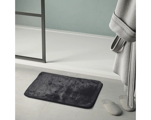 Tmavě šedá koupelnová předložka vedle sprchového koutu, županu a pantoflí