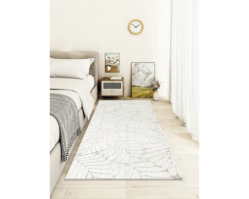 Ložnice s postelí, nočním stolkem a vzorovaným kobercem