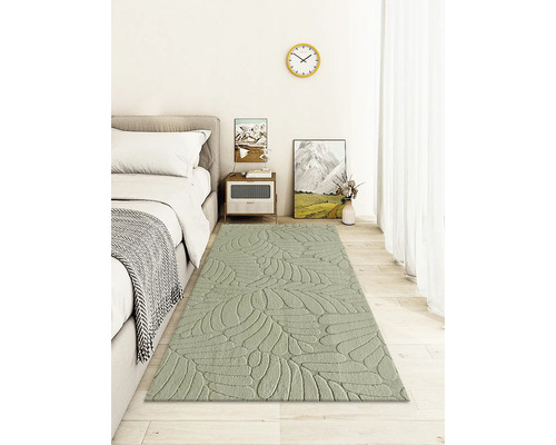 Ložnice s postelí, nočním stolkem a kobercem s motivem listů