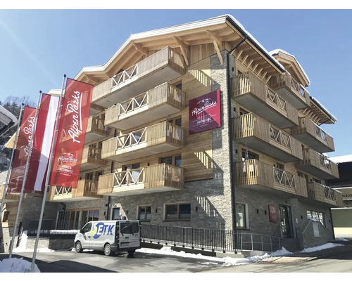 Vnější pohled na vícepodlažní budovu s balkony a logem Alpen Parks