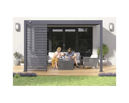 Rodina relaxuje pod moderní pergolou s lamelovou střechou a zahradním nábytkem na dřevěné terase