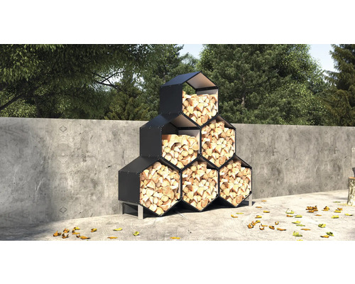 Regál na dřevo s šestiúhelníkovými přihrádkami naplněnými palivovým dřívím ve venkovním prostředí